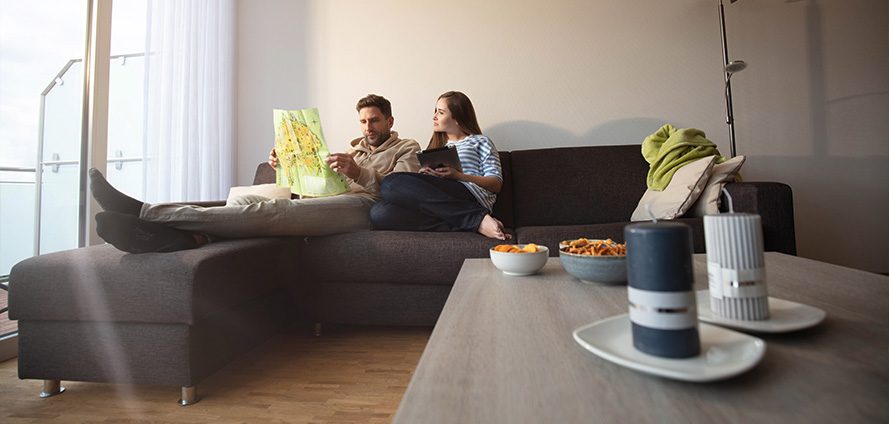 Zwei Gäste mit Laptop auf dem Sofa einer Wohnung im Tönsberghaus