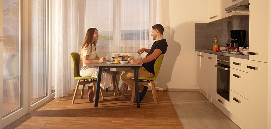 Gäste am Esstisch in der Küche einer Wohnung des Tönsberghauses