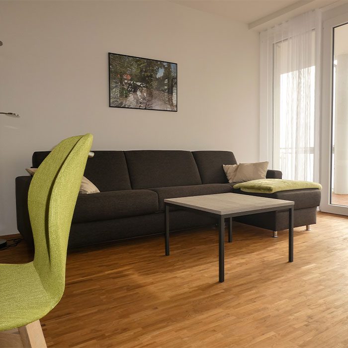 Wohnbereich mit Sofa und Balkontür in einer Wohnung des Tönsberghauses